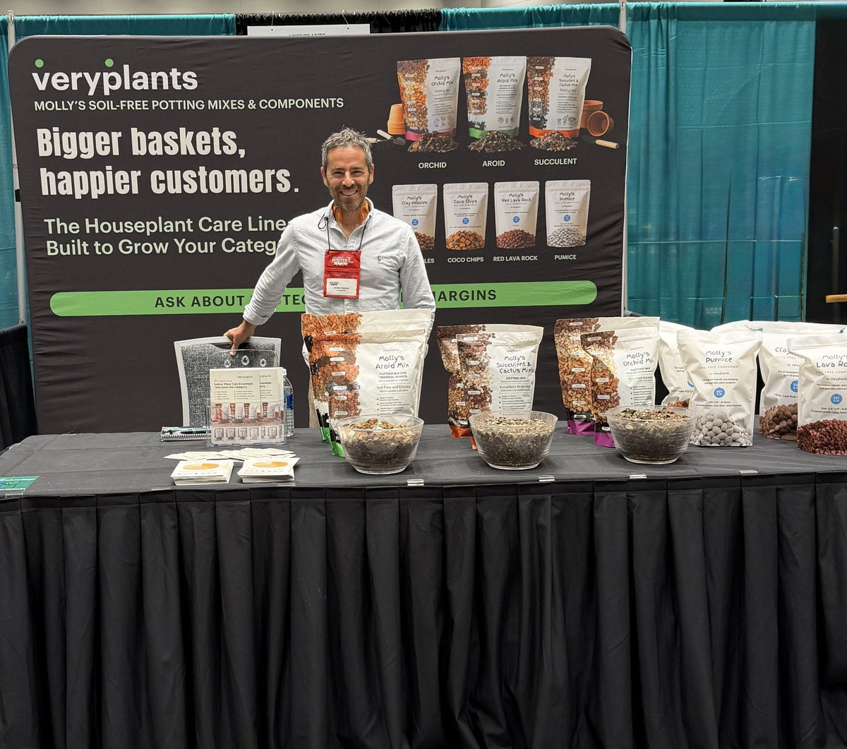 Jordan Socran, Veryplants co-founder, at booth 178 at Foster's Spring Market in Mankato, Minnesota, with Molly's Aroid, Succulent, and Orchid mixes and the four Molly's Components on the table.